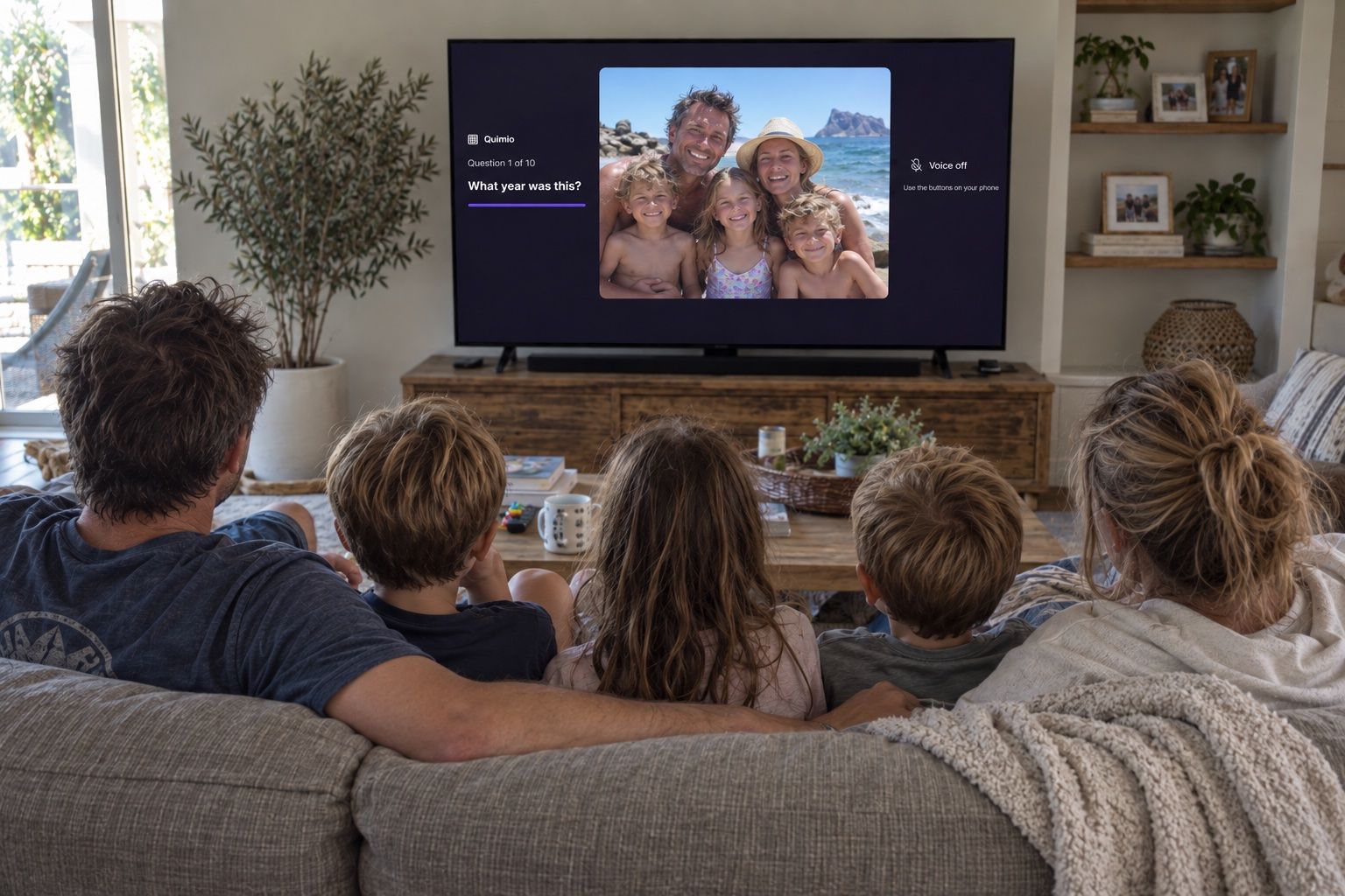 A family playing Quimio on the sofa with their photos on the TV